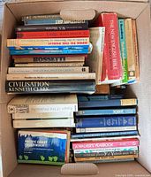 Open box showing mixed hardcovers & paperbacks stacked, spines visible