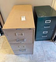 Beige 2-drawer and green 3-drawer metal filing cabinets side by side