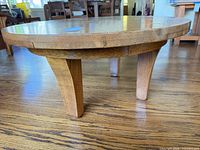 Side view showing three splayed oak legs and round top