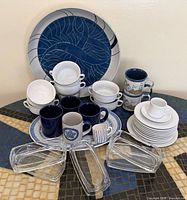 Entire lot with platters, bowls, mugs, plates, cups, saucers and glass trays