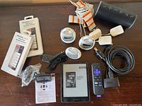 Entire lot showing Kindle, Roku, VTech monitors, speaker, adapters, cables, screen protectors