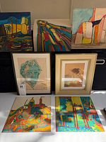 Overview of eight artworks arranged on table and backdrop