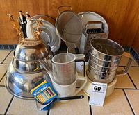 Group shot of entire lot showing mixing bowls, bakeware, utensils, candles and figurine