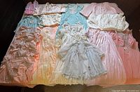 Wide shot of all pastel nightgowns, robes and jackets laid on bed