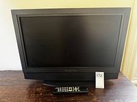 Front view of Olevia TV with remote and lot tag