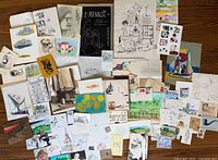 Wide overview of all drawings, paintings, sketches and ephemera spread on floor