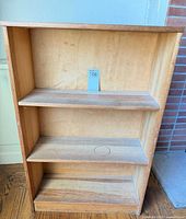 Front view of pine bookcase showing shelves and unfinished wood