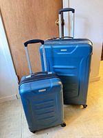 Large and small Samsonite teal hardside spinner suitcases with handles extended