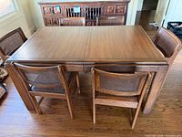Dining table with six caned chairs, view from end
