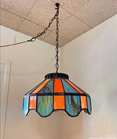 Full view of hanging stained glass pendant lamp with chain and cord