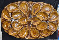 Full view of oval brown glazed oyster platter showing 21 wells