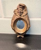 Front view of jester wall mirror showing sculpted face, costume details and round mirror