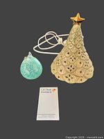 Ceramic tree, glass ornament and cord shown together