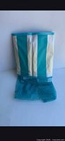 Folded turquoise and white striped water hammock with mesh center visible