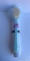 Body brush packaged and bath mat rolled together