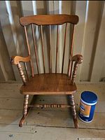Front view of child wooden rocking chair on wooden floor