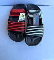 Two pairs of kids slides size 13 with tags attached, showing color variations