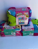 Front view of three sealed Shopkins fleece throw kits