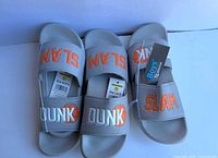 Three pairs grey slides with tags visible
