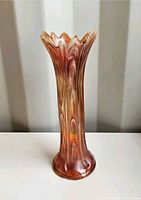 Full view of marigold carnival glass swung vase