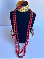 Full lot on display bust: two bead necklaces, both earrings, painted bangle