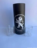 Two glasses and black Lion Collection tube