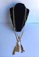 Necklace double-draped on bust showing pearls, clear stones and twin tassel pendant