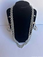 Necklace displayed on bust with earrings clipped on sides