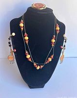 Necklace, earrings and brooch displayed on stand