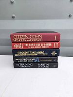 Stacked view of five hardcover books showing spines and titles
