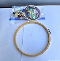 Large hoop alongside bag of small hoops and floss