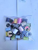 Bag containing 27 assorted small spools of vintage thread