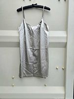 Front view of silver slip dress hung on hanger