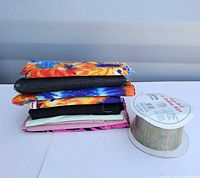 Stack of assorted fabric remnants with ribbon spool