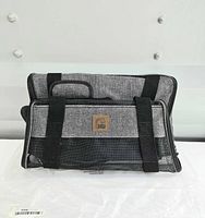 Front view of grey fabric carrier with mesh front and logo patch