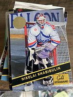 Stack of assorted hockey cards, top card Nikolai Khabibulin Gold Standard