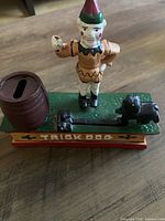 Trick Dog bank front view showing clown, dog, barrel and lettering
