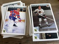 Stacks of Ultimate hockey cards; top visible cards Bobby Hull, Leonard Kelly, Keith McCreary
