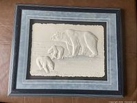 Overall view of framed bas-relief polar bear artwork showing frame, matting, and signed relief