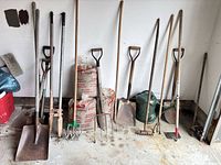 Group shot of all garden tools, watering can, and sand bags