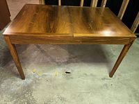 Front three-quarter view of wood dining table showing overall form and condition