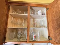 Cabinet shelves showing full assortment of glassware and mug