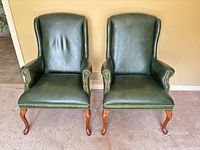 Front view of both green leather wingback armchairs