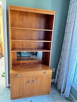 Front view of closed bookcase showing shelves and cabinet doors