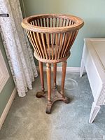 Full view of wooden plant stand beside window