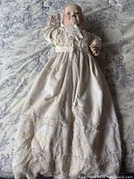 Full view of baby doll in christening gown