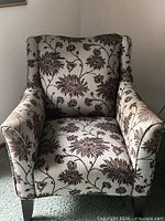Front view of first armchair showing upholstery pattern and arm style