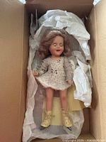 Doll in box with tissue wrapping showing full outfit and skates
