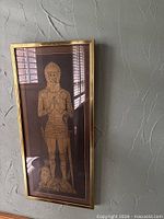 Vertical framed medieval knight artwork on textured wall