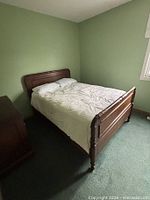 Full view of assembled wood bed frame with headboard and footboard